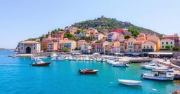 Ambiance de voyage évoquant Le Caire : port méditerranéen aux eaux turquoise et aux toits de tuiles