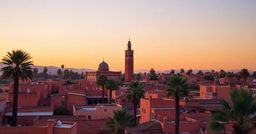 Minaret de la Koutoubia et toits ocre de la médina de Marrakech au coucher du soleil
